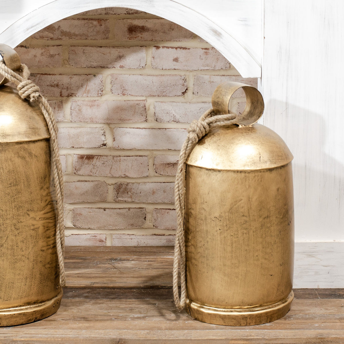 Gold distressed metal bell with braided rope hanger and rounded top loop