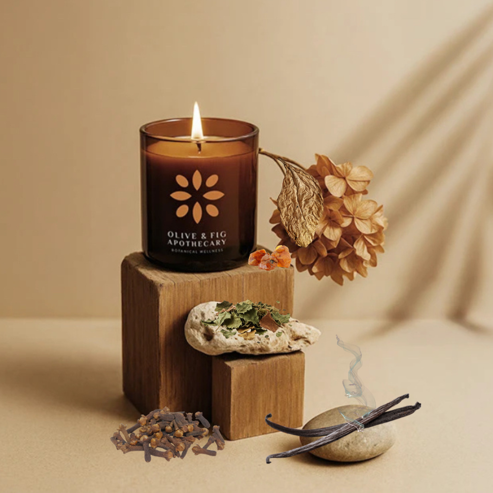 Burning amber glass candle with botanical flower emblem on the front