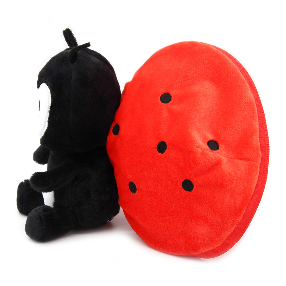 Black ladybug plush beside red tomato-shaped shell with dotted wing pattern