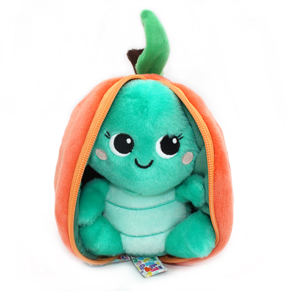 Green plush turtle face inside peach orange flip-top pouch, smiling