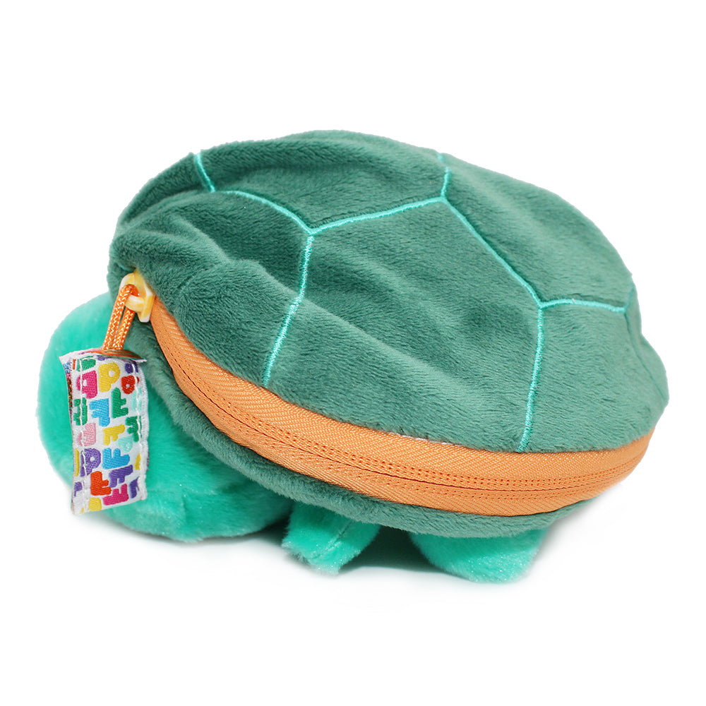 Green plush turtle resting in shell with orange zipper trim and green body