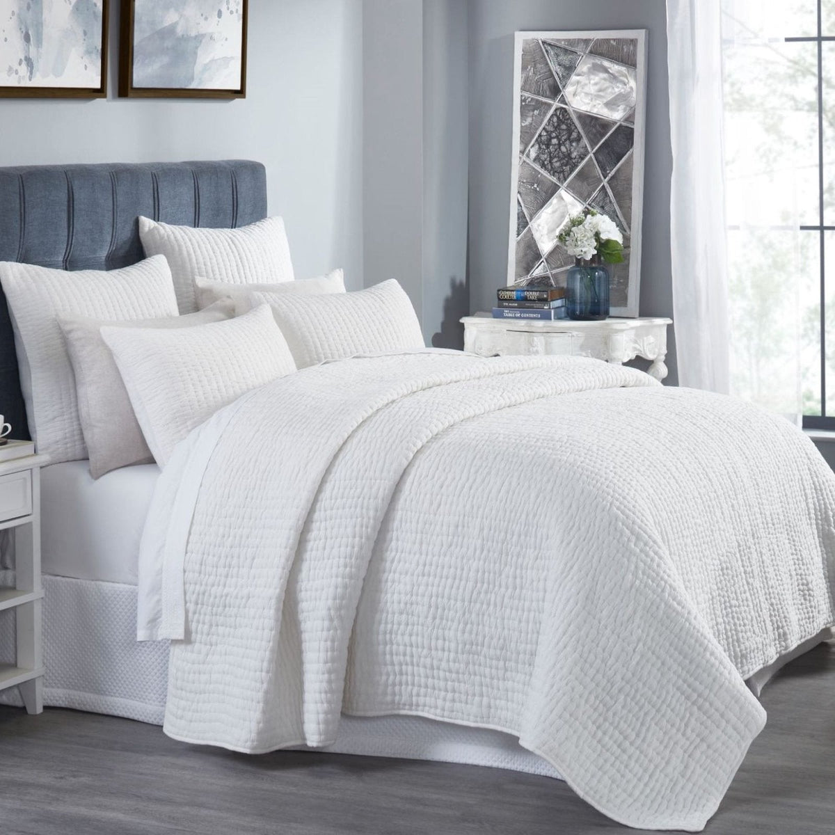 Off-white washed cotton quilt with textured crinkle weave draped over bed