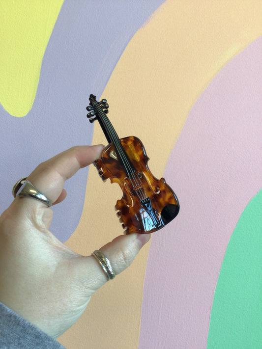Violin-shaped hair claw in amber and dark brown with glossy finish