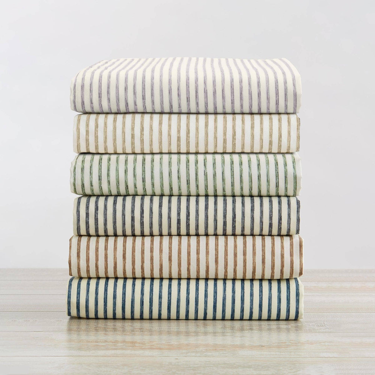 Striped microfiber sheet set stack in blue, green, and tan stripe patterns