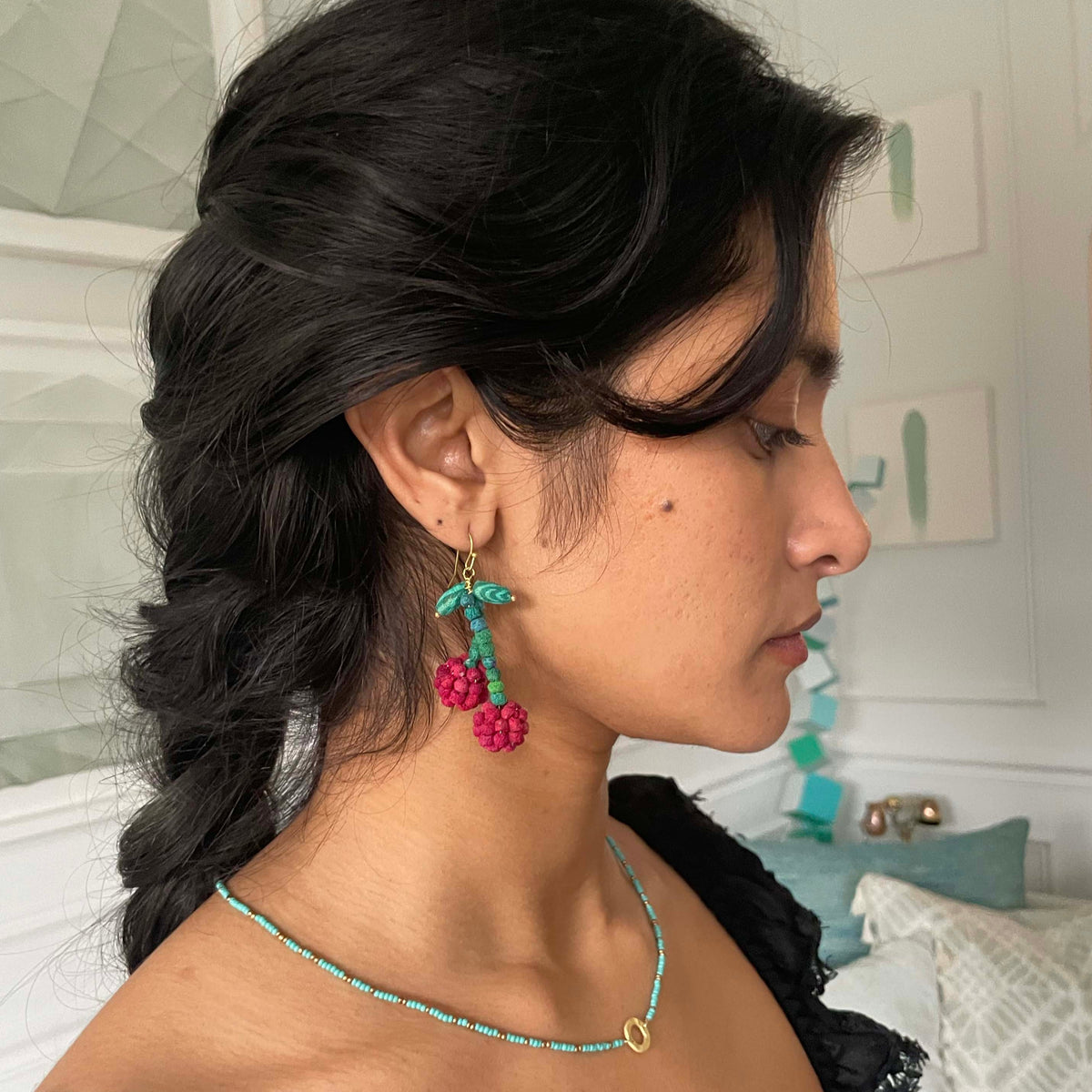 Teal and red beaded earrings with gold hooks, leaf accents, and berry pom-poms.