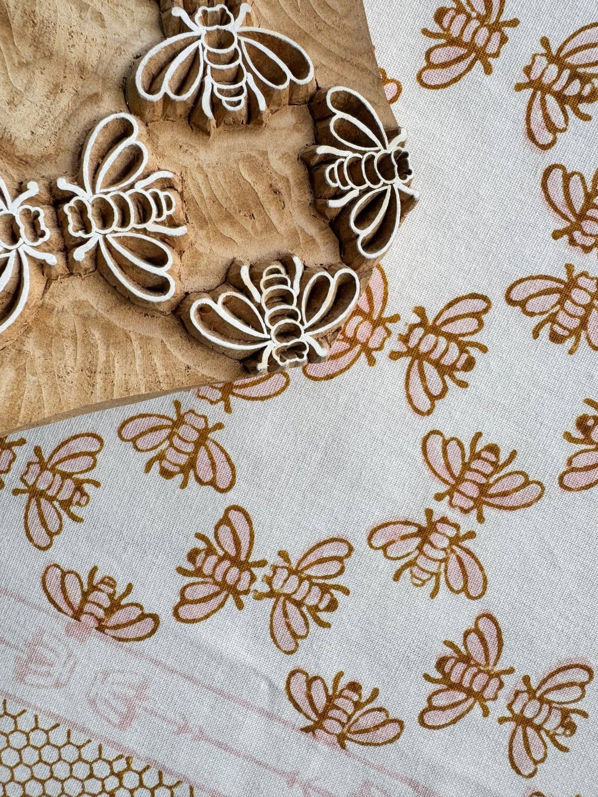 White table throw with honeybee cluster and vine pattern in rose and mustard