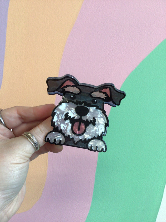 Black-and-white dog hair claw with wagging tongue, held in hand