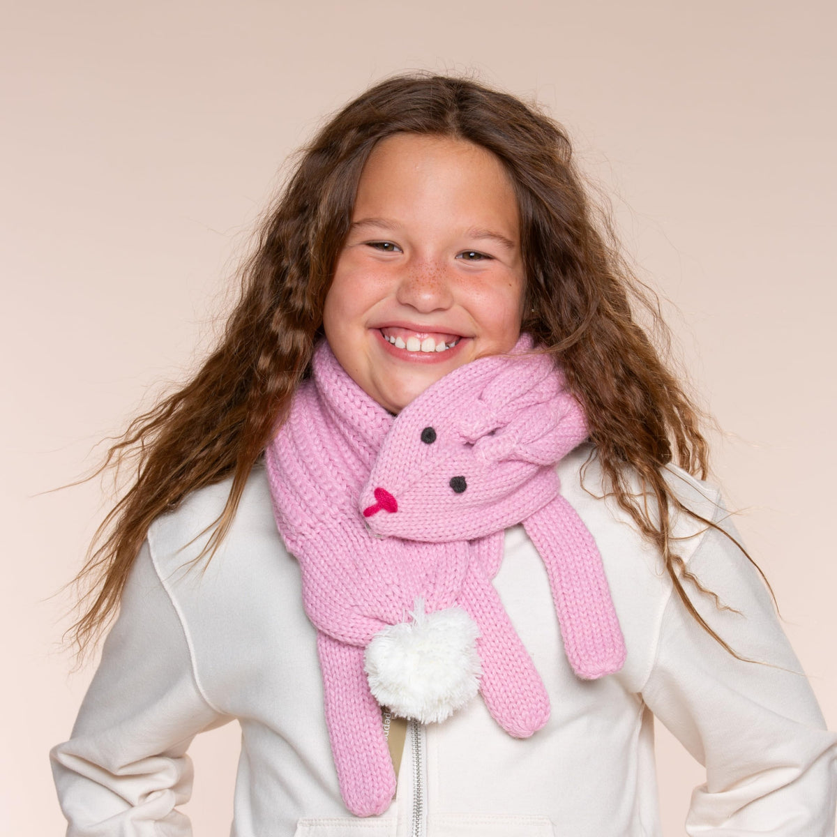 Pink knitted children's scarf with a bunny face, long ends, and a white pom-pom