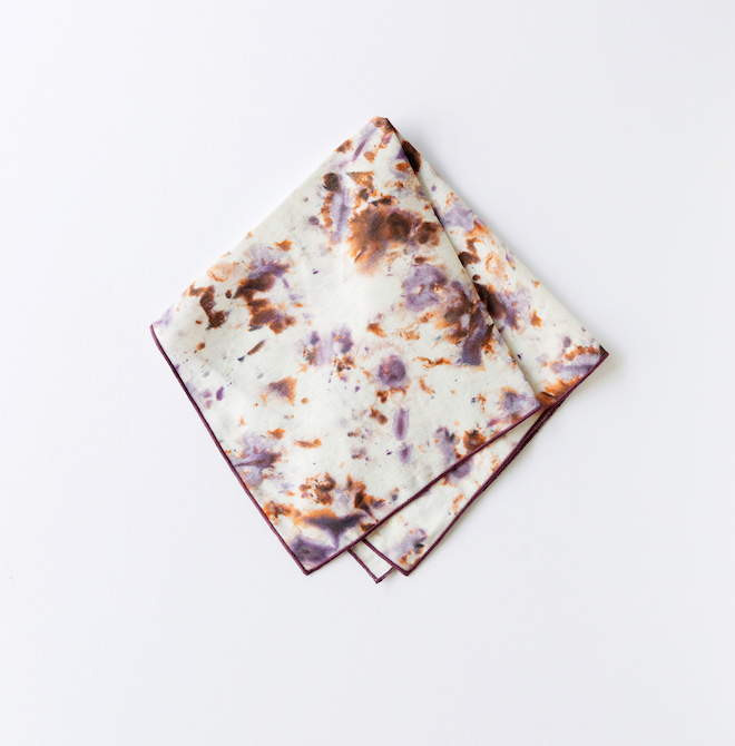 Rose marble napkin set, white with multicolor splatter design and dark plum trim border.