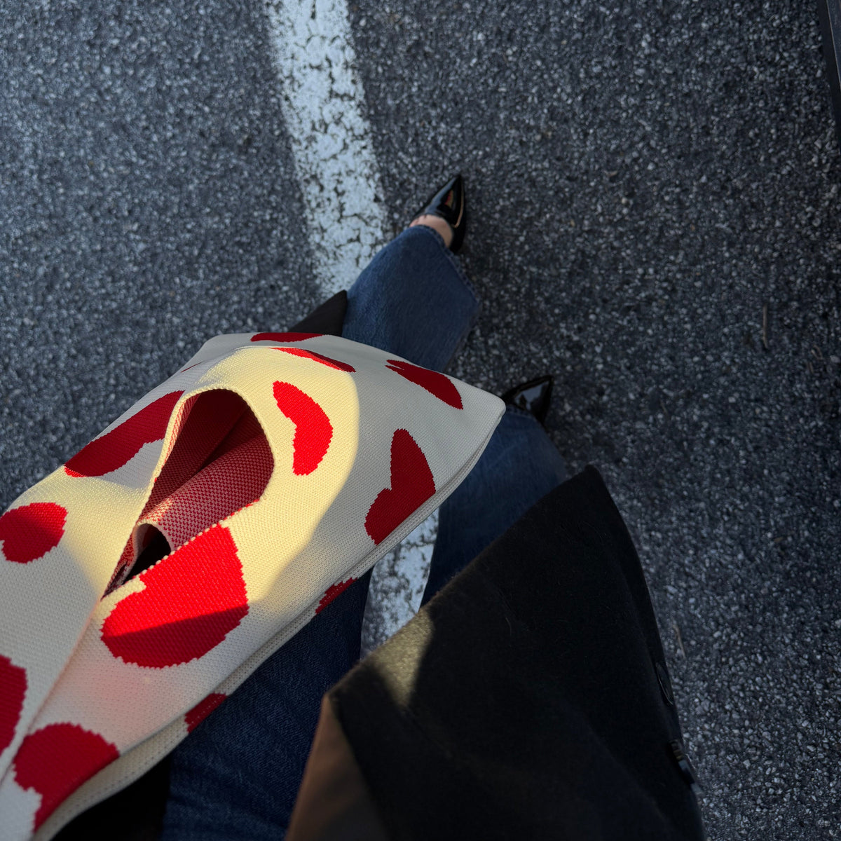 Cream heart-print handbag with red hearts, cropped side view