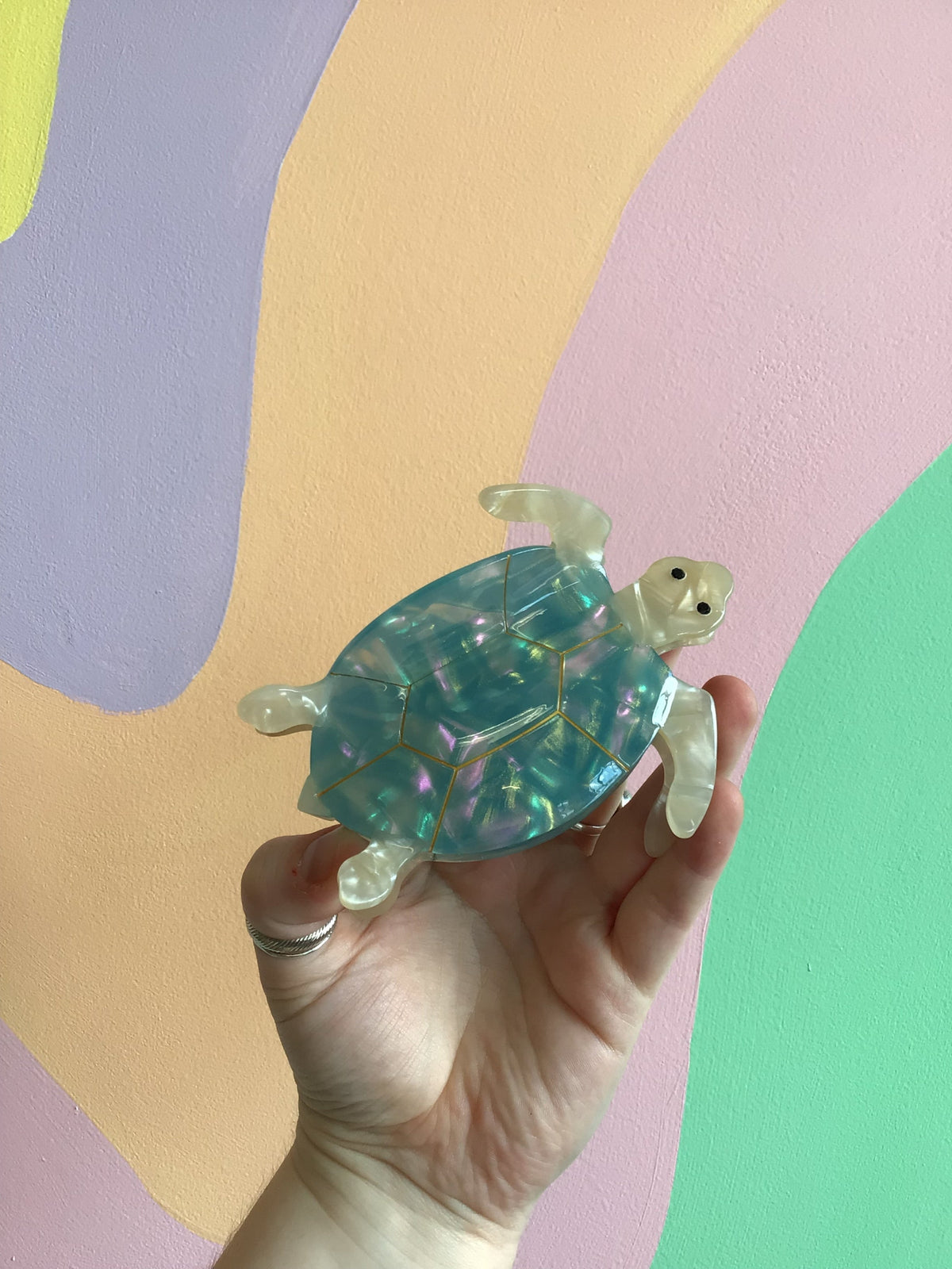 Sea turtle hair claw with translucent teal shell and pale spotted flippers