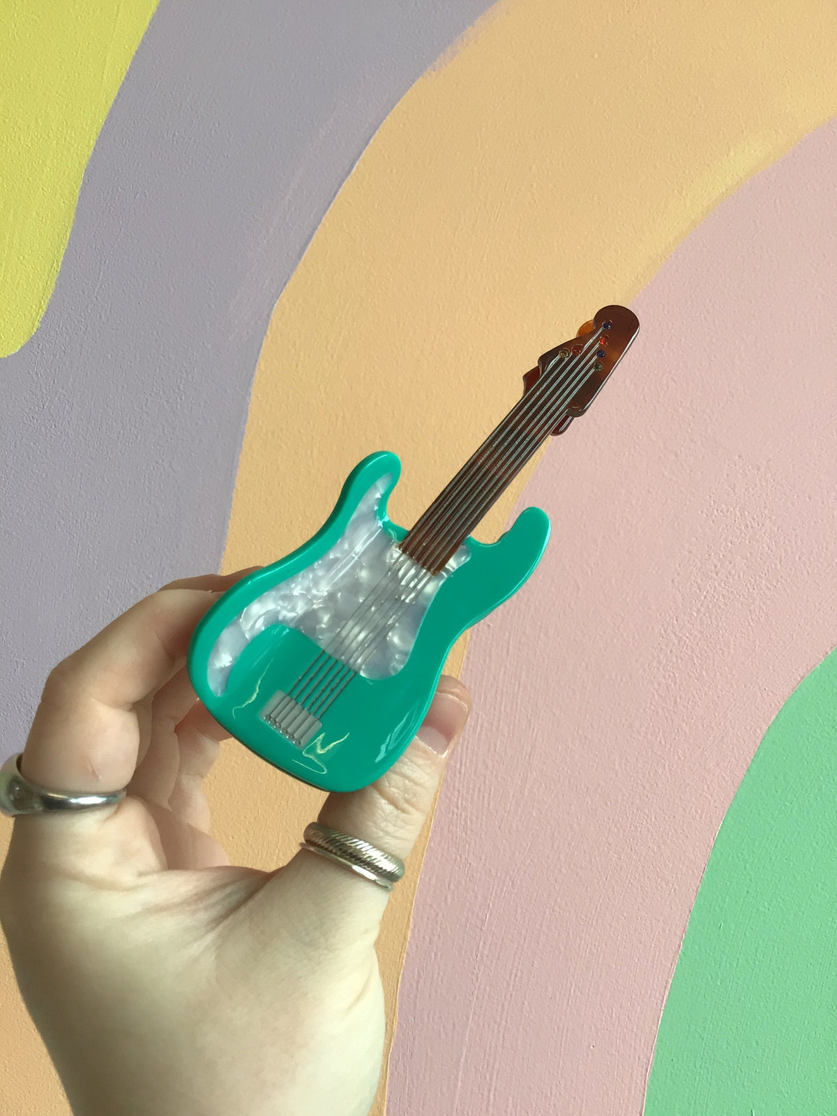 Turquoise electric guitar hair claw with black trim and silver string accents