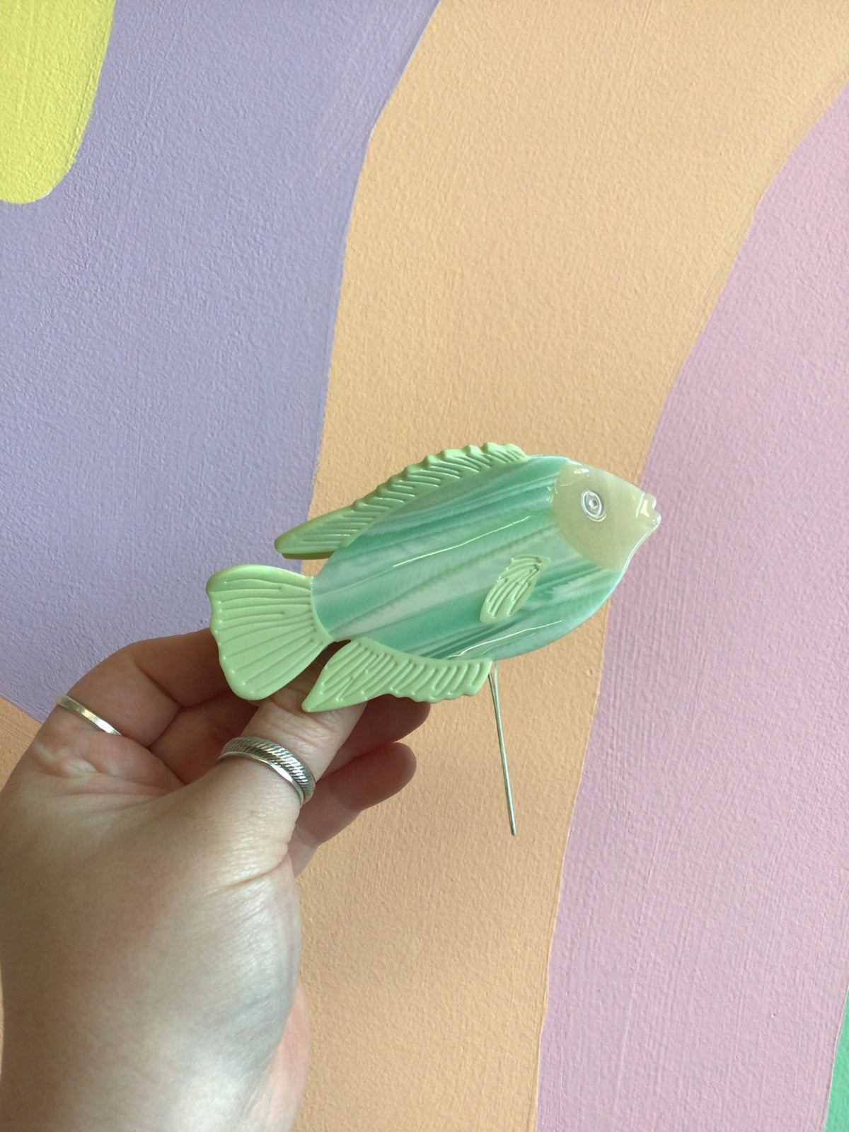 Green fish hair claw with translucent scales and small pin comb teeth.