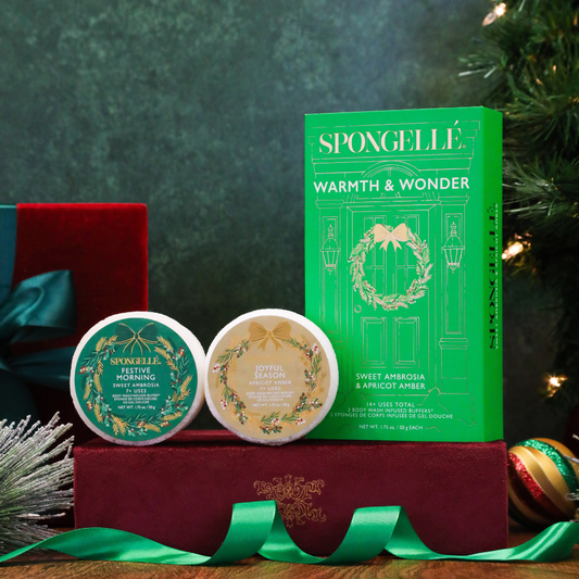 Holiday gift set box with two round body cleanser tins and green ribbon