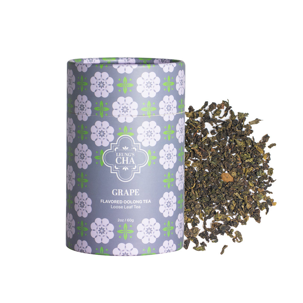 Flavored oolong tea canister with purple grape floral design, with loose tea leaves beside it