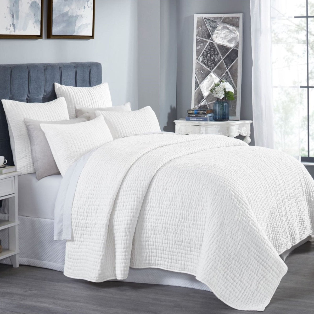Off-white washed cotton quilt with textured crinkle weave draped over bed