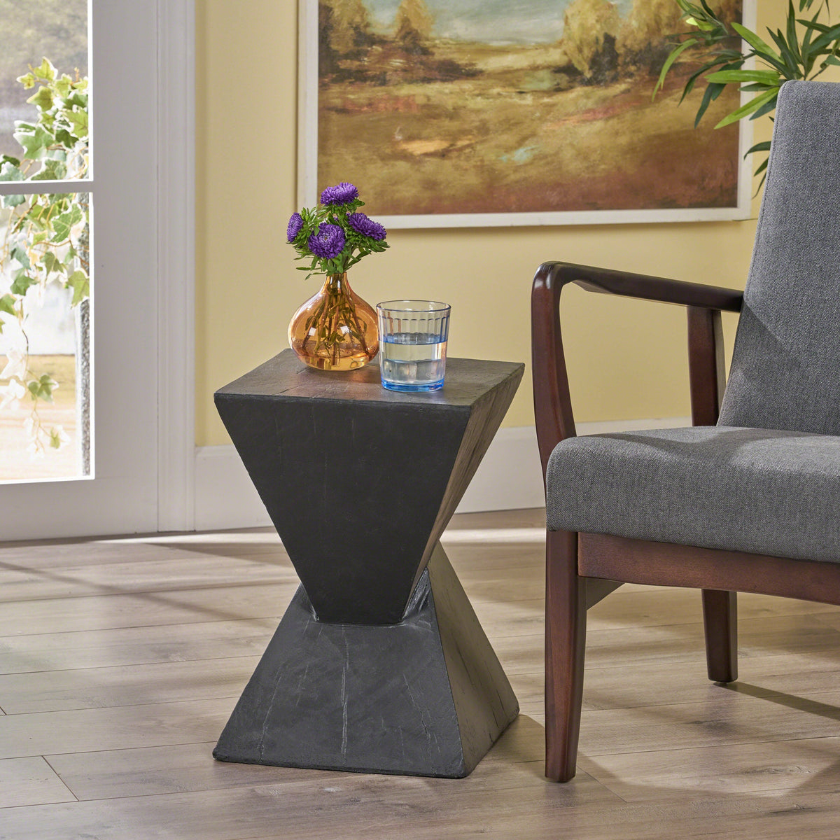 Black hourglass side table with a square top and sculptural base