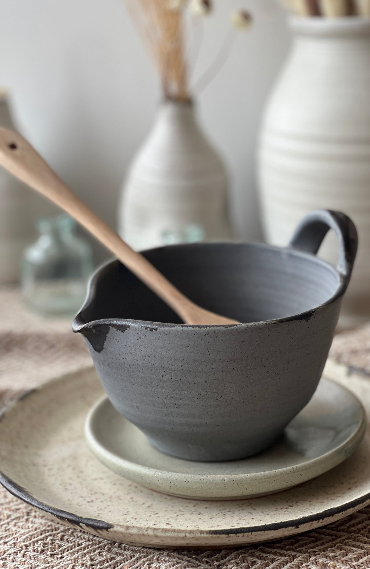 Dark gray stoneware batter bowl with handle and speckled glaze for mixing batter