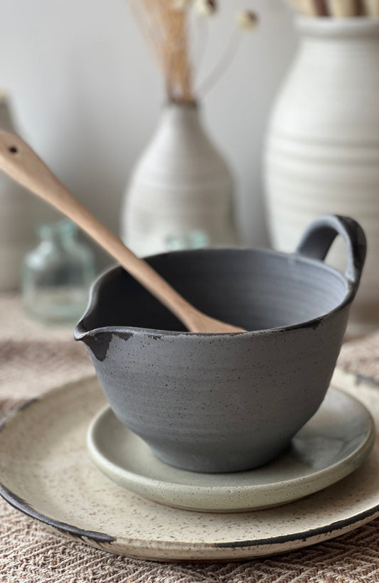 Dark gray stoneware batter bowl with handle and speckled glaze for mixing batter
