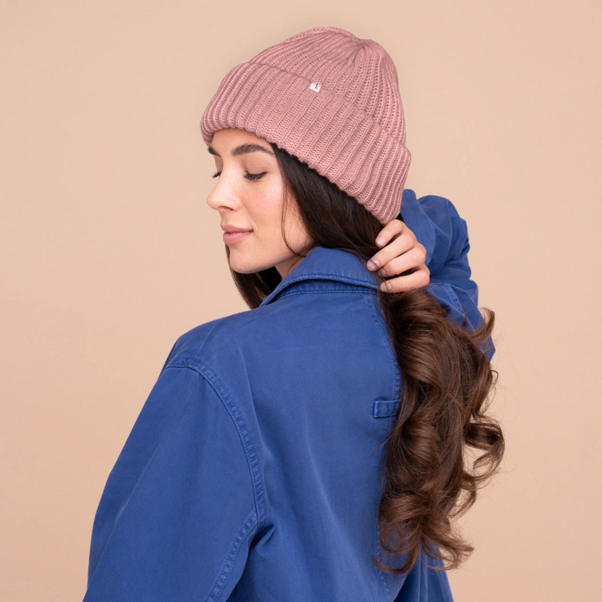 Blush ribbed knit beanie worn with folded cuff
