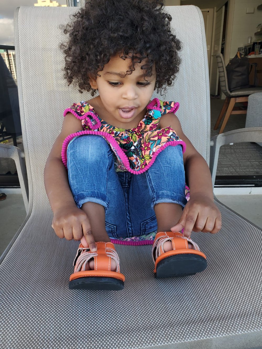 Kids orange barefoot sport sandals on child’s feet, hook-and-loop ankle straps