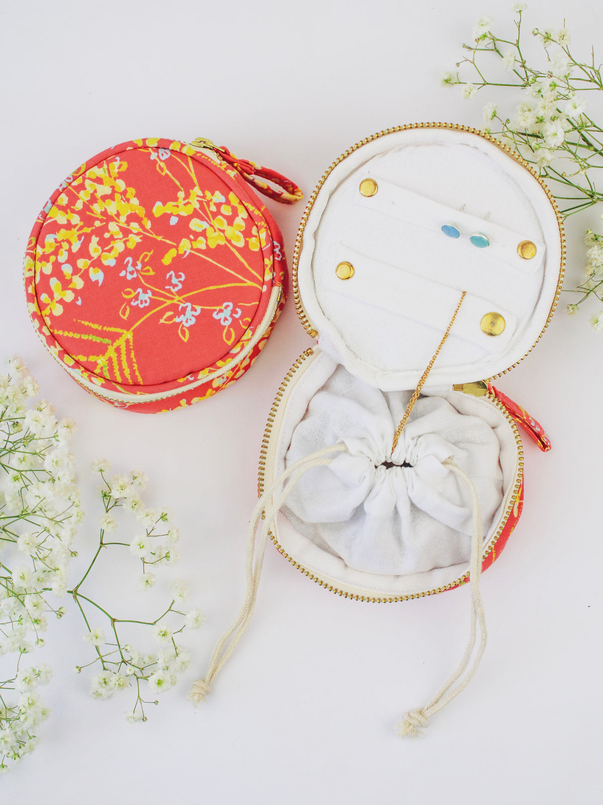 Round coral floral jewelry pouch with zip closure, open display with earring slots