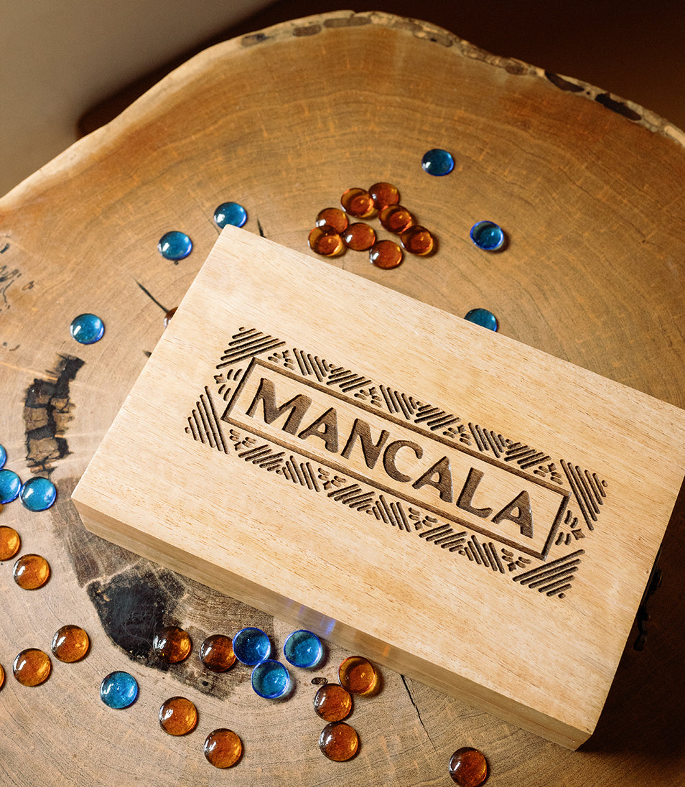 Mancala wooden game board with “MANCALA” carving and multi-color marbles on mango wood