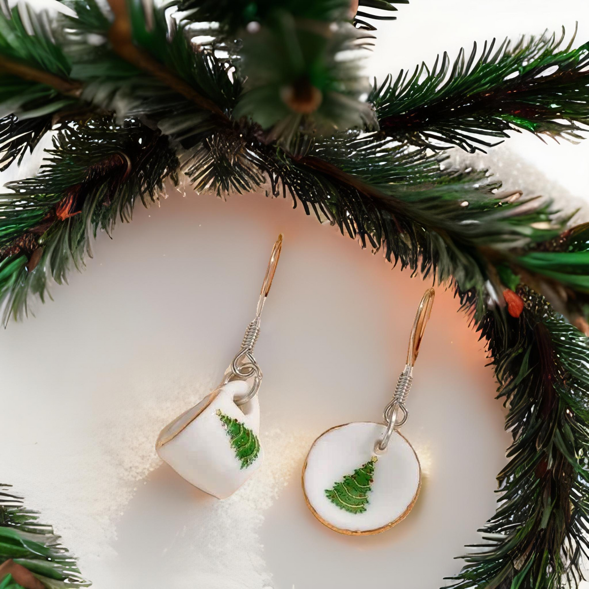 Dangling tea cup earrings with green tree detail on white ceramic-style charms