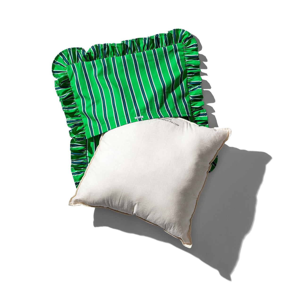 Green vertical stripe ruffle cushion cover beside a solid cream pillow