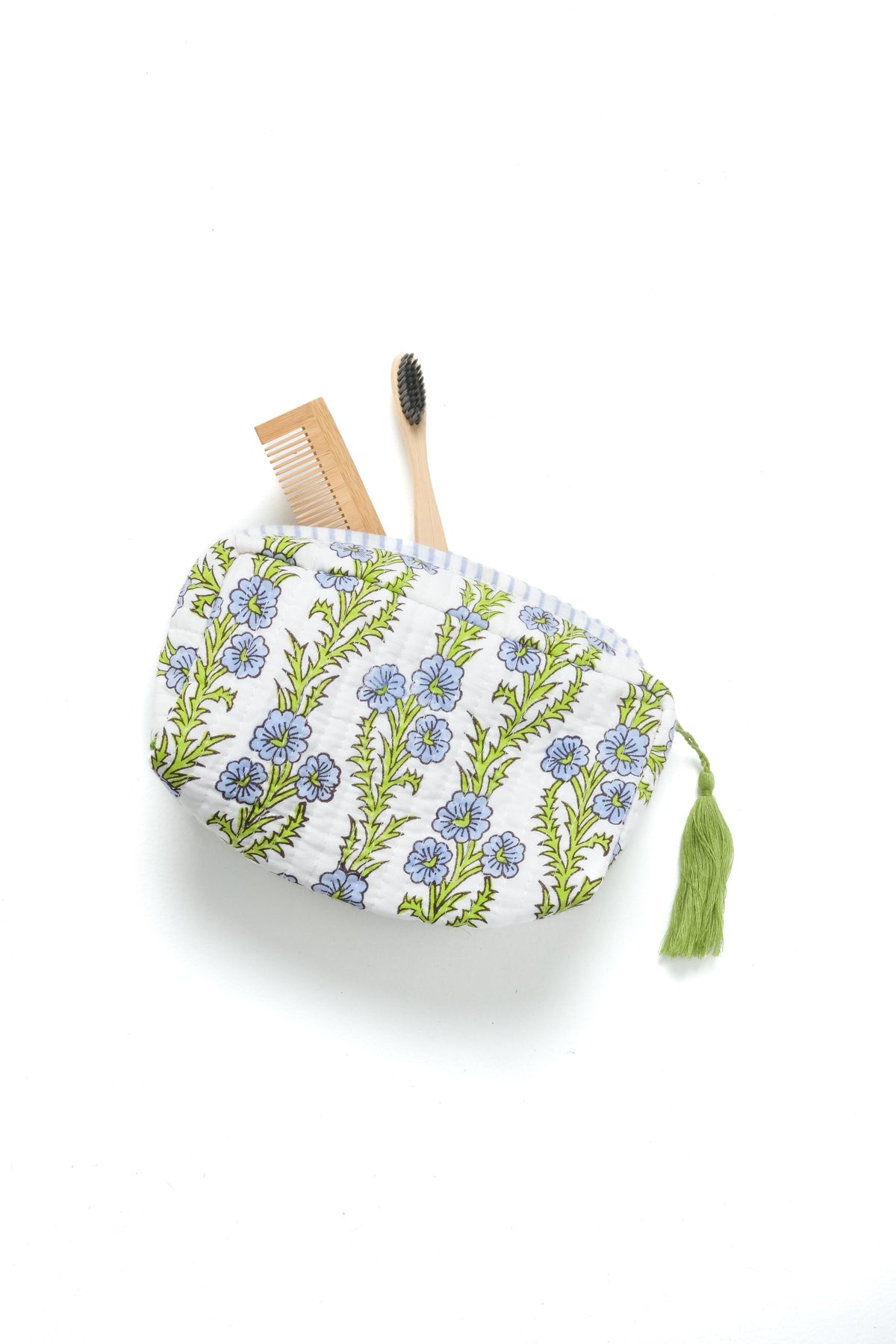 Blue floral blockprint makeup bag with zipper, holding a wooden brush and comb.