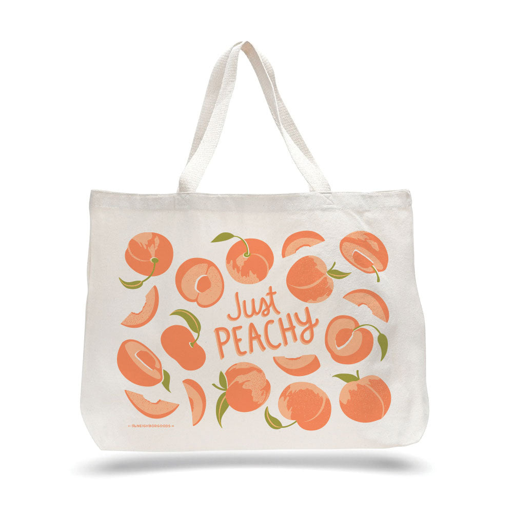 Cream canvas tote bag with orange peach illustration and “Just Peachy” lettering