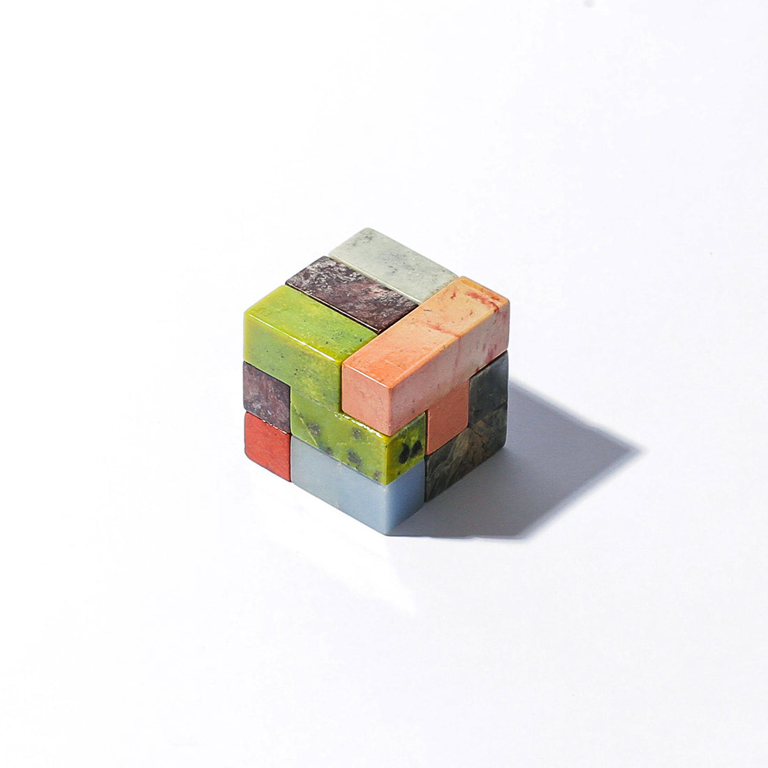 Gemstone cube puzzle with multicolor stone blocks, square interlocking design.