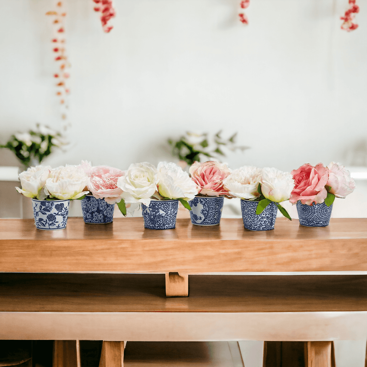 Mini chinoiserie cachepots with bouquets of flowers in small blue-and-white patterned planters