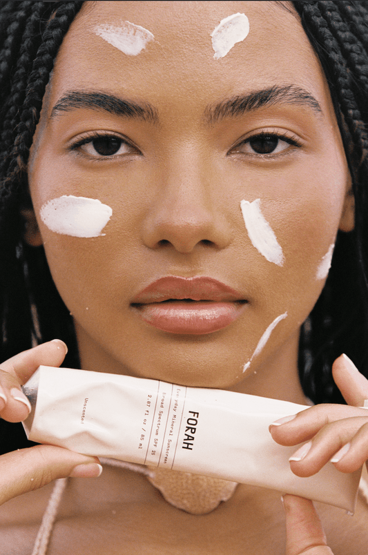 Mineral sunscreen on face with white patches; holding sunscreen tube