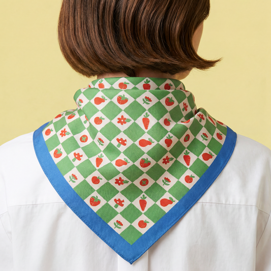Cotton bandana worn at neck with green-and-white checker print, red motifs, blue edging