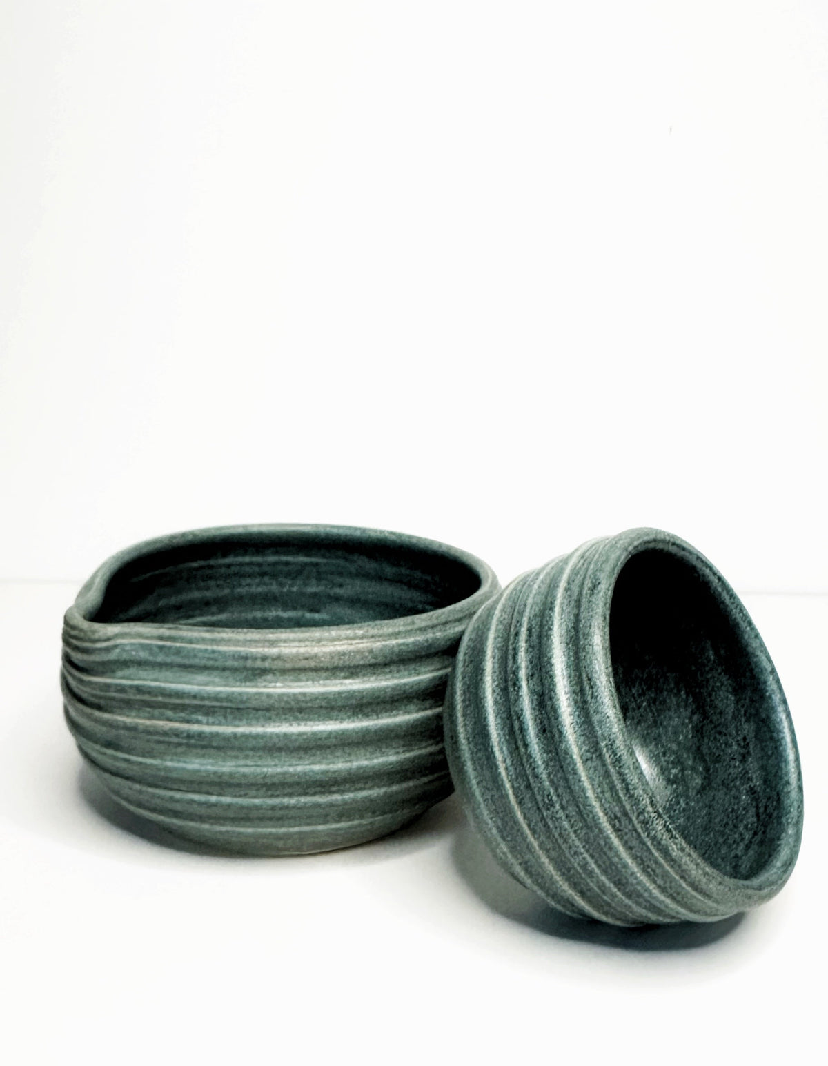 Forest green ceramic matcha bowl set with mini cup, textured glaze, stacked bowls.