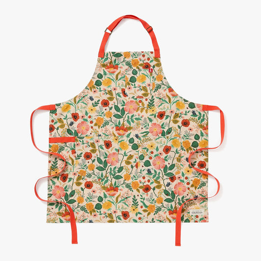Floral canvas apron with orange straps and side ties, cream background