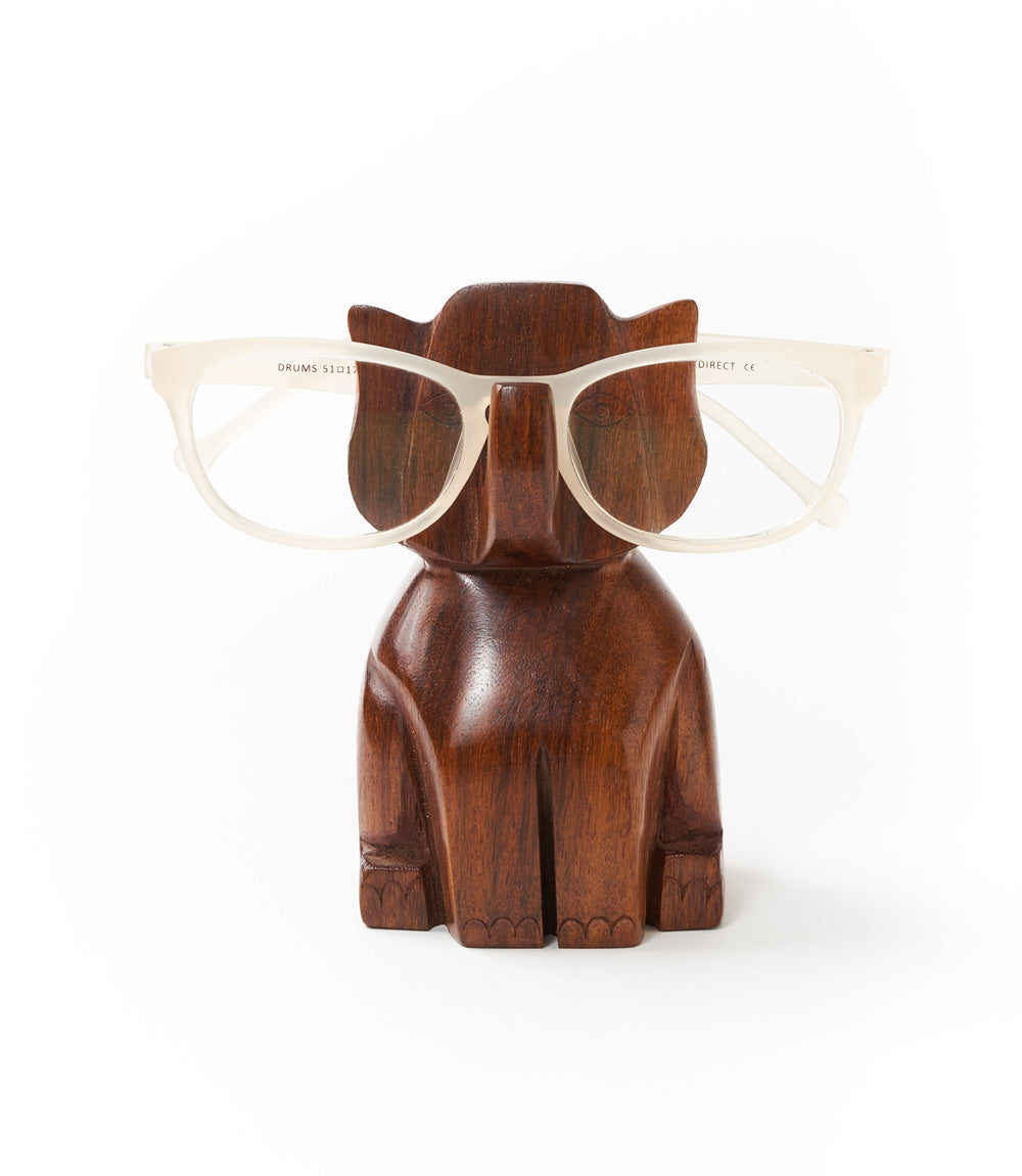 Hand-carved dark wood elephant eyeglass holder with eyeglasses on upper carved support