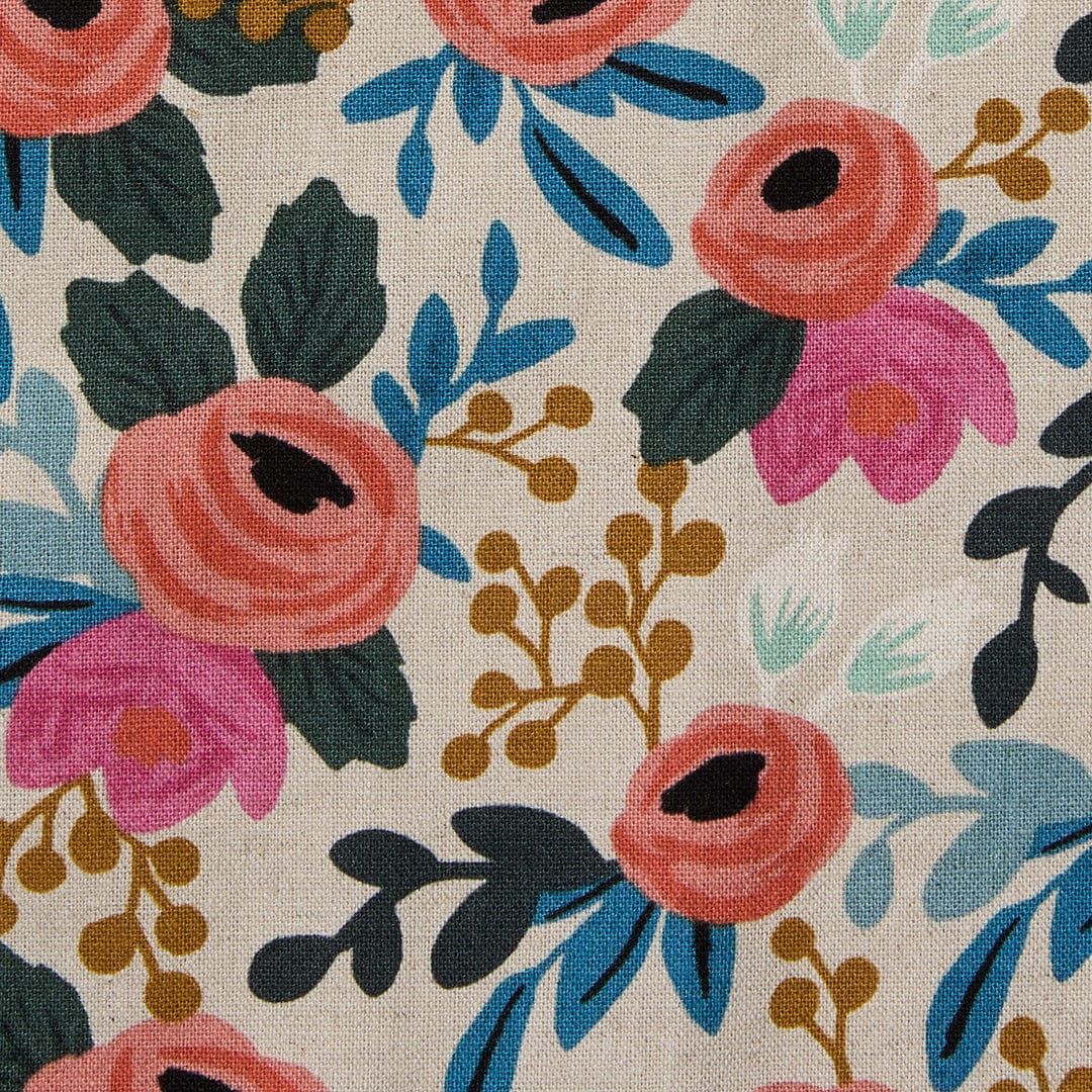 Floral crossback apron fabric with colorful flowers and leaves on natural canvas.