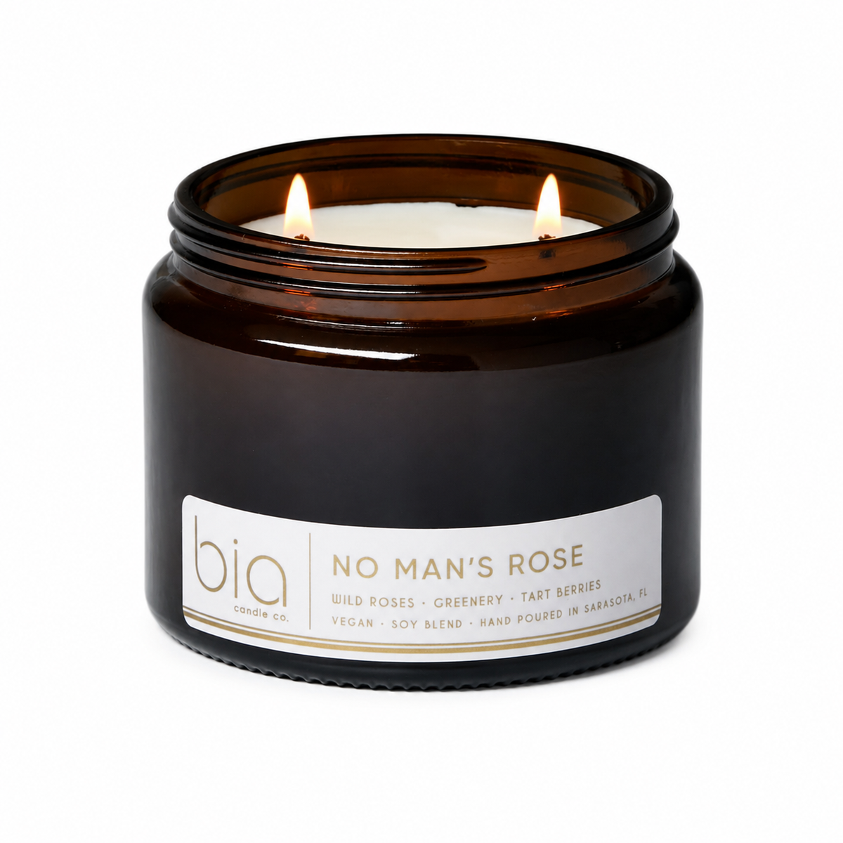Amber glass soy blend candle jar with lit wick and printed label
