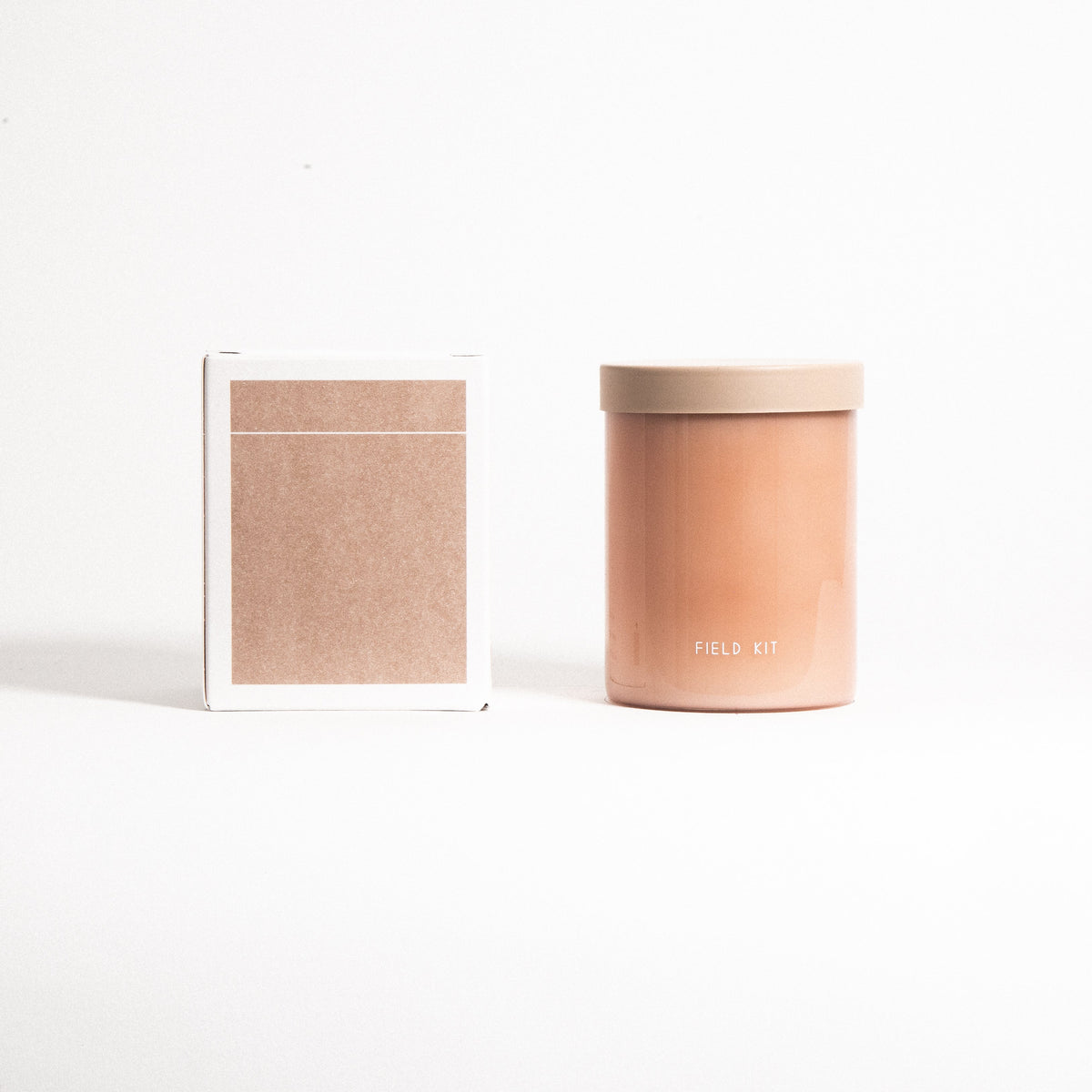 Florist candle amber jar with tan lid next to 'FIELD KIT' gift box