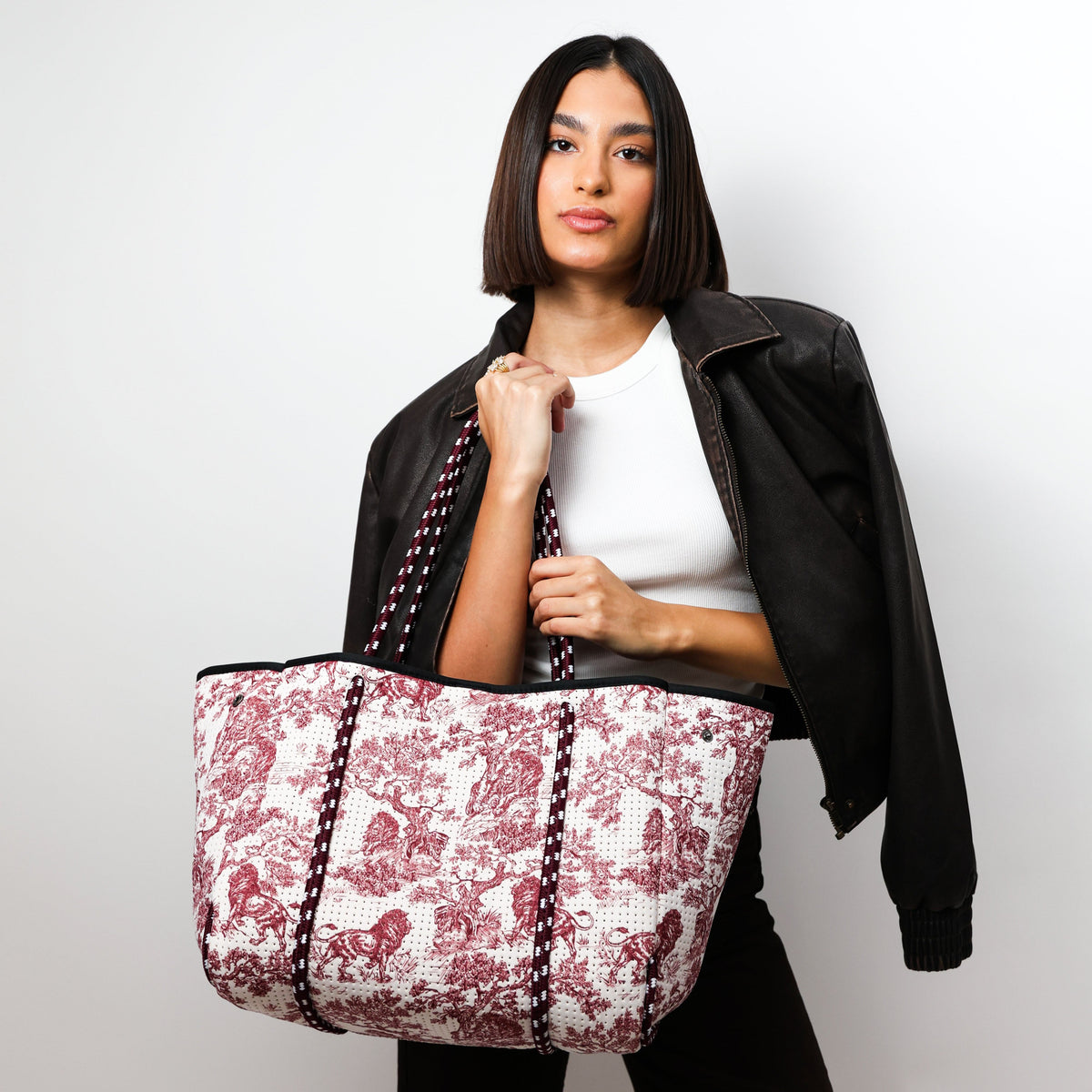 Red-and-white printed tote bag with black double handles, open top, central panel