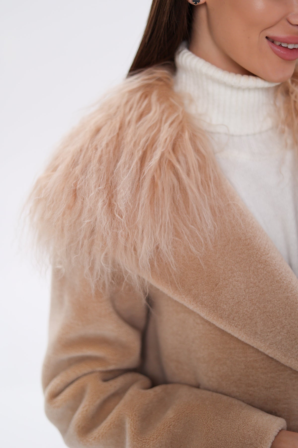 Close-up of the coat's shaggy fur collar and soft beige wool sleeve