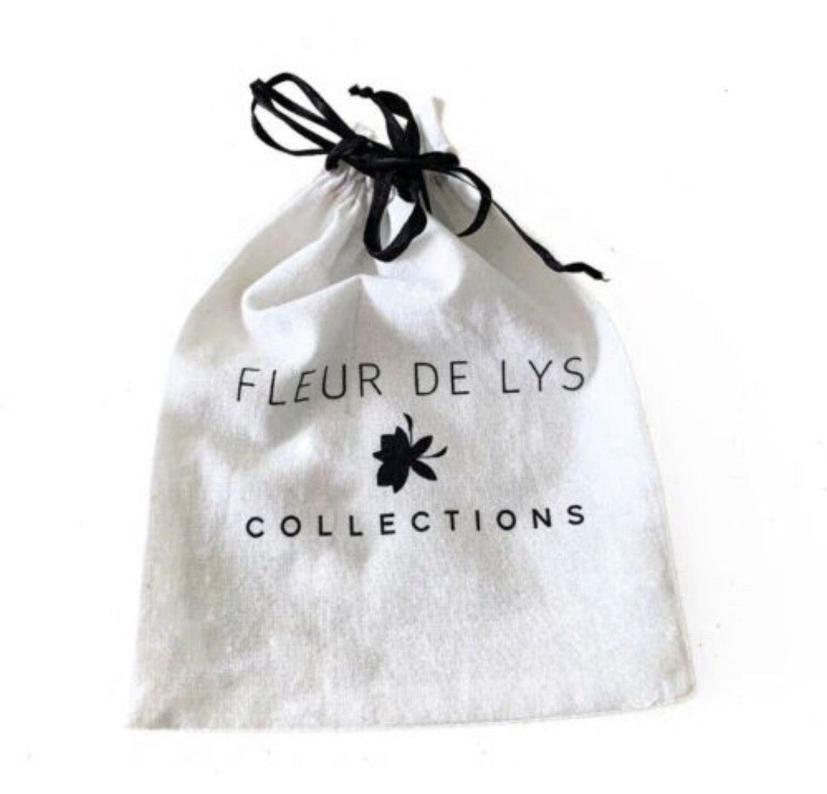 White drawstring pouch with black ribbon, featuring FLEUR DE LYS COLLECTIONS text