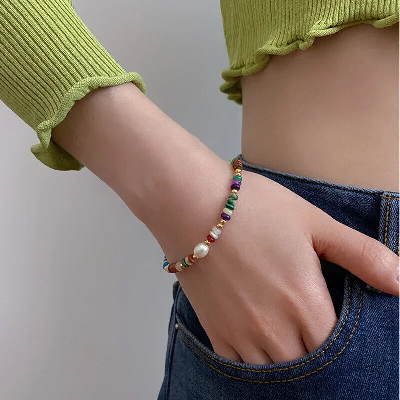 Multicolor bead bracelet worn on wrist with gold-tone clasp