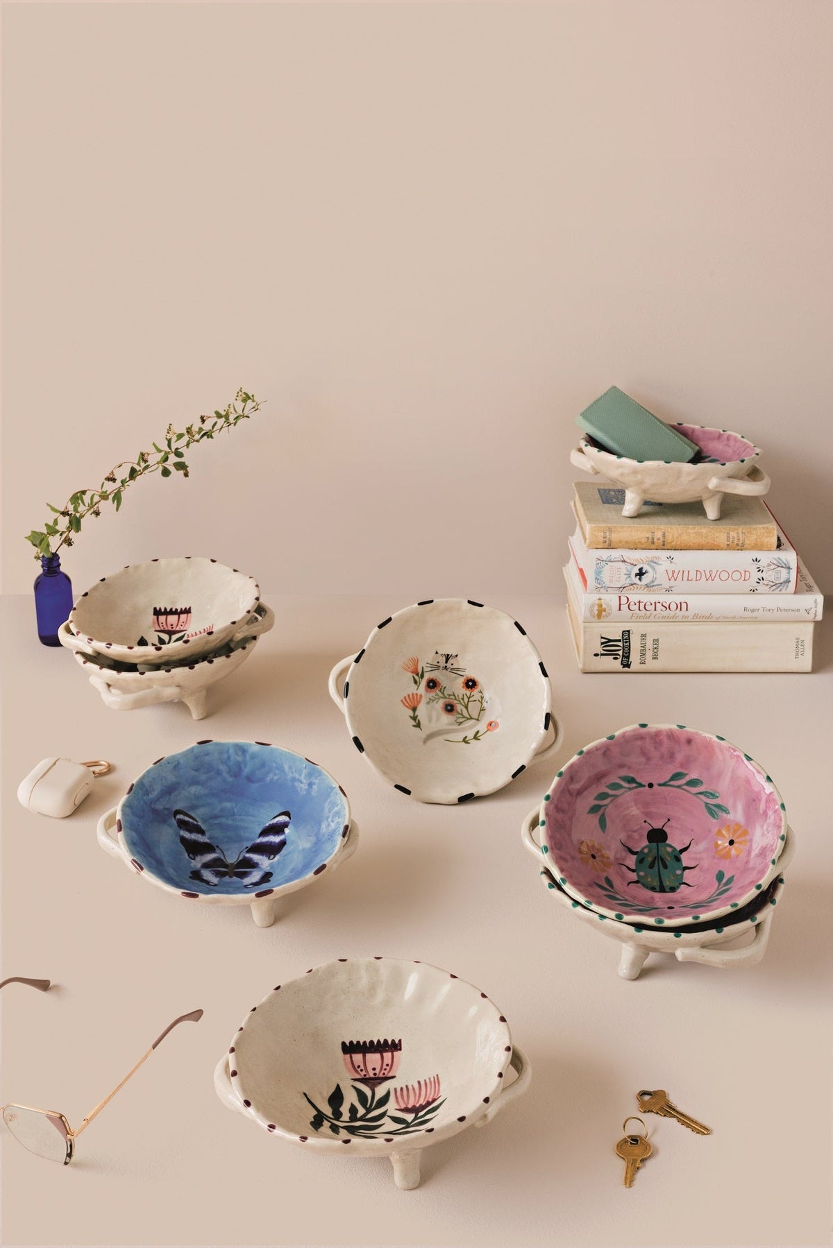 Set of two blue footed ceramic bowls with animal faces, shown among other designs