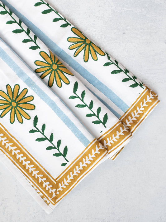 Table throw with blue stripes, green leaf print, and mustard fringe border.
