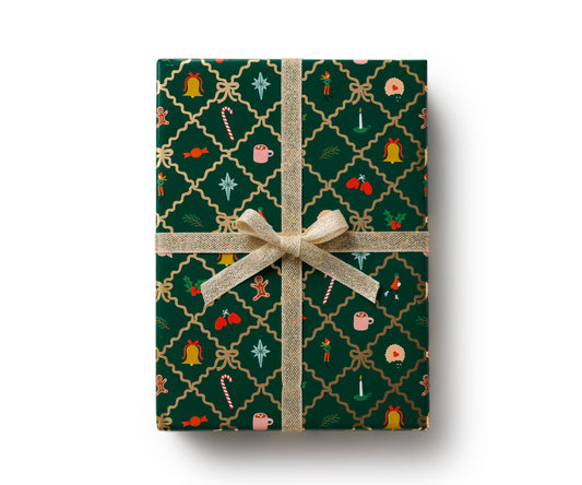 Holiday gift wrapping paper with green gingerbread and holly pattern, tied with gold ribbon bow