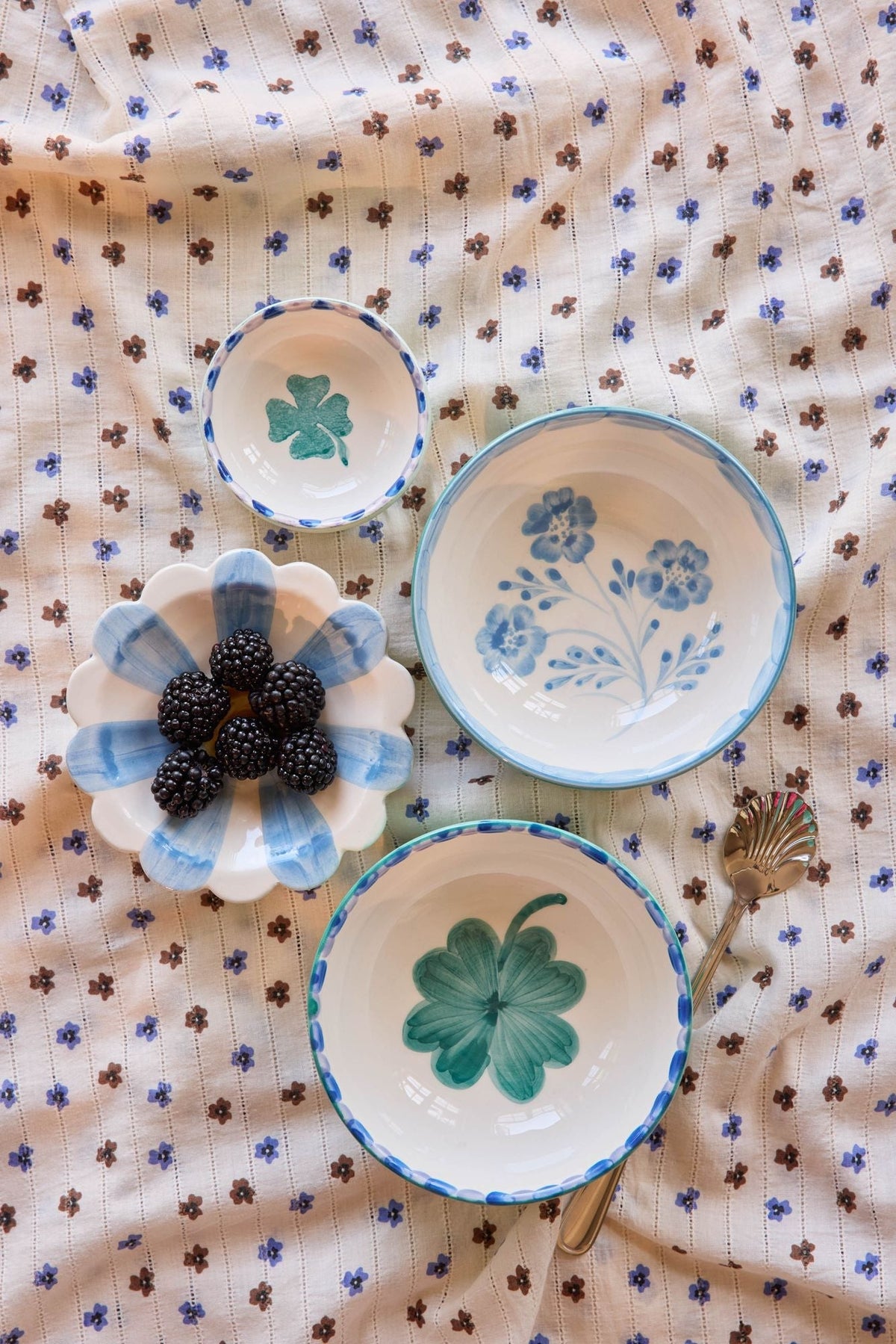 Ceramic bowls with hand-painted blue florals and green leaf design, round glazed white