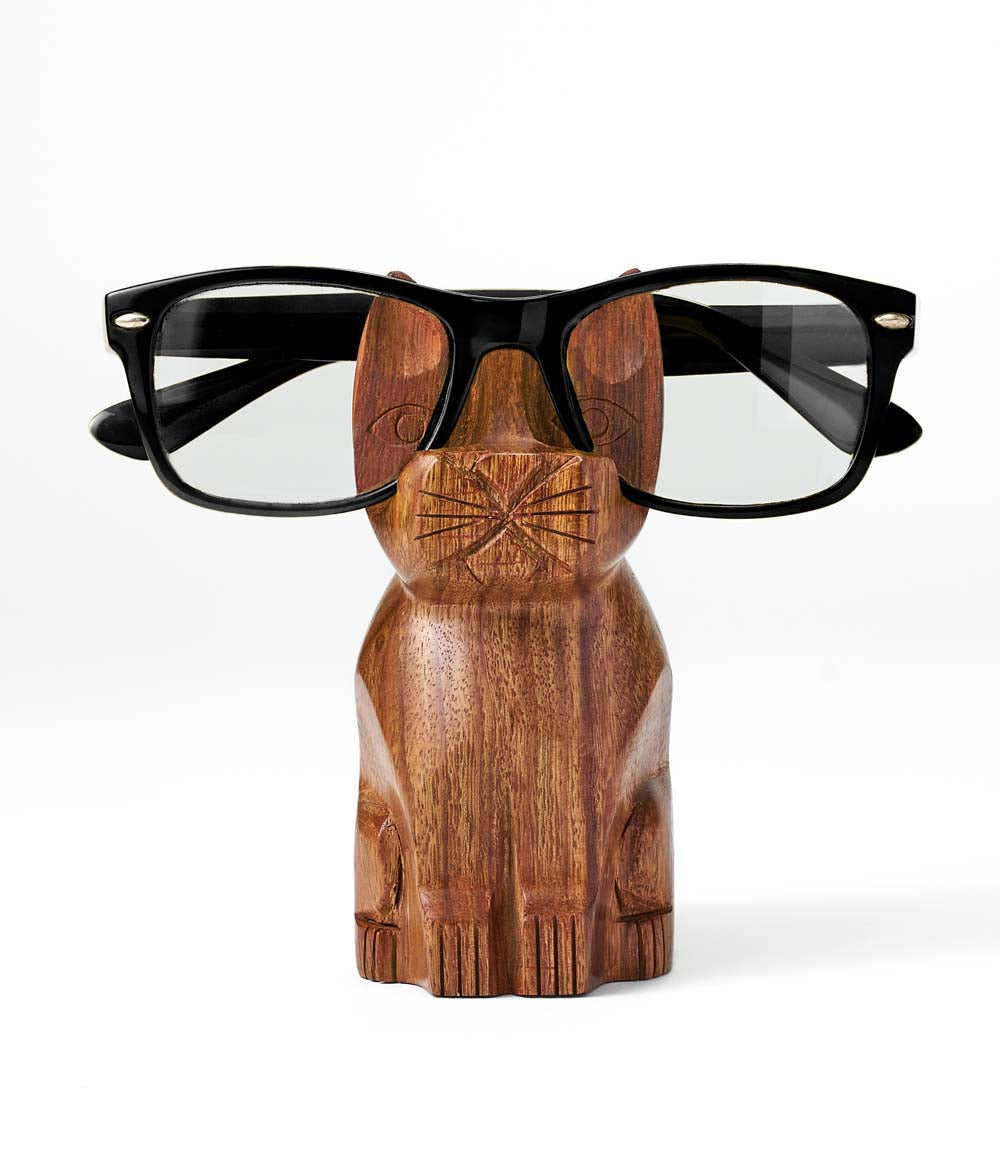 Hand-carved wooden cat eyeglass holder stand with black glasses resting on top